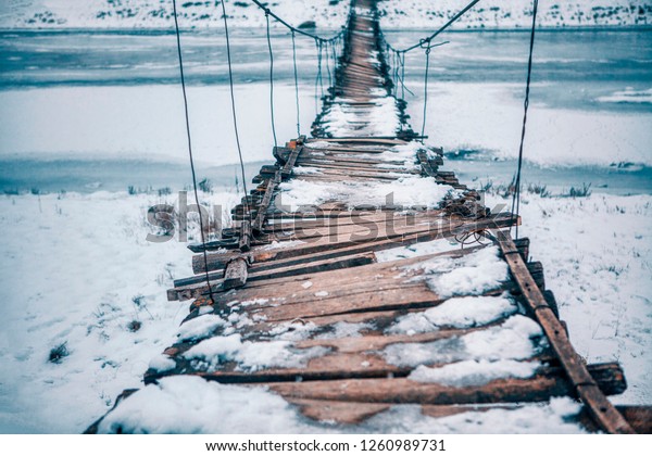 rope bridge broken and\
covered by snow 