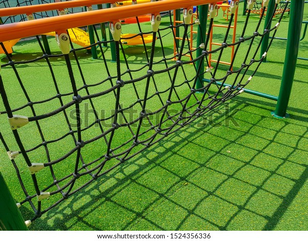 Rope bridge for children to play at playground on\
green grass
