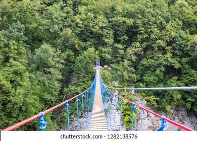 Rope Bridge Over A Large Green Canyon