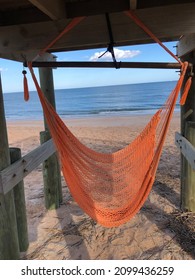 A rope chairs under a walkover provides shade at the ocean - Shutterstock ID 2099436259