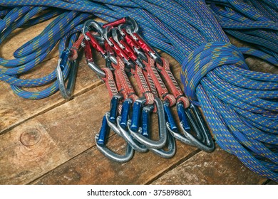 Rope And Equipment For Climbing And Mountaineering On Wooden Boards. Carabiners And Slings