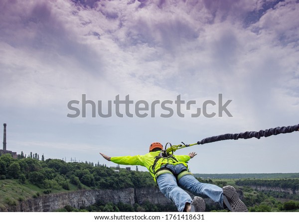 Rope jumping. Man\
jumping from the bridge