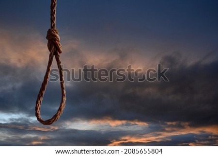 Rope noose on dramatic blue sky. Space for text