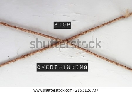 Rope on wall with text STOP OVERTHINKING, self remind to break cycle of thinking too much, becoming self-aware and drive towards better, faster decisions