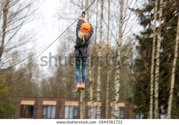 Rope park - climbing center. Hiking in rope park\
girl in safety equipment. Roping park. Child boy. Volga, Tver\
Oblast, Russia October 2020 Portrait of cute little boy and girl\
walk on rope bridge