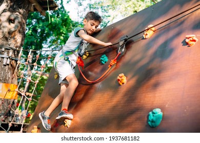 Rope Park. The kid passes the obstacle in the rope Park - Powered by Shutterstock