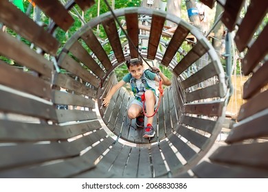 Rope Park. The Kid Passes The Obstacle In The Rope Park