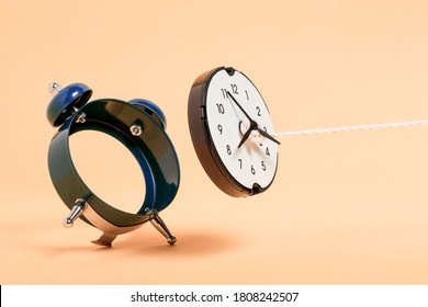 rope pulling out clock face from alarm clock, abstract time concept