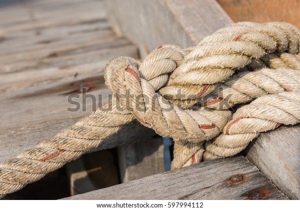 Rope tied up to a knot\
on a wood bridge