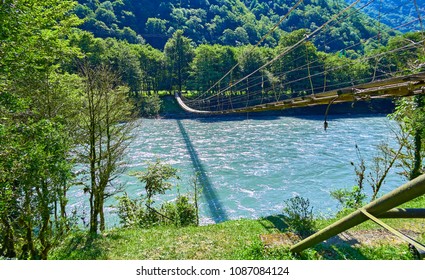 Rope Wooden Bridge Hanging Over Wild Cold River In Summer Abkhazia