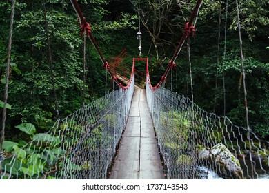 Rope Wooden Bridge Hanging Over Wild Cold River In Summer, Georgia