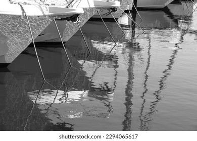 Ropes and reflections of boats moored at the dock in Spain