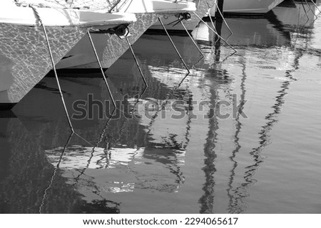 Ropes and reflections of boats moored at the dock in Spain