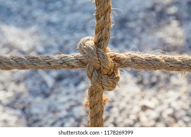 Ropes tied in knot on abstract grey background