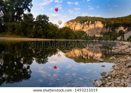 Roque-Gageac, Dordogne, France. Hot air balloons in the early morning float over the tufa cliffs and the dordogne river