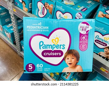 Ros, CA - January 21, 2022: Hand Holding A Box Of Pampers Cruisers Diapers Inside A Large Department Store.