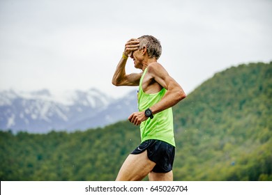 Rosa Khutor, Russia - May 7, 2017: Old Man Runner On Water Point In Hand Sponge With Water In Spring Mountain Marathon