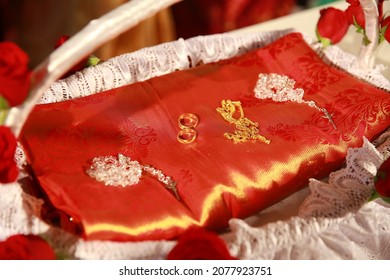 Rosaries and wedding rings decorated on a red wedding saree during a kerala catholic wedding