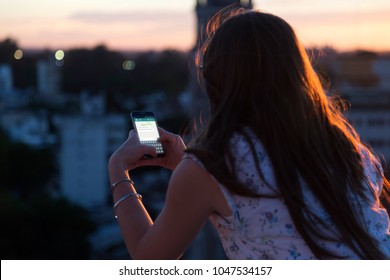 ROSARIO, ARGENTINA - NOVEMBER 8, 2017: Girl With Smartphone In Her Hands And A Whatsapp Conversation On The Screen. Young Woman, Millennial, Chatting. Technology. Communications.