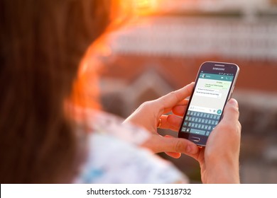 ROSARIO, ARGENTINA - NOVEMBER 8, 2017: Girl with smartphone in her hands and a whatsapp conversation on the screen. Young woman, millennial, chatting. Technology. Communications.