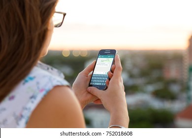 ROSARIO, ARGENTINA - NOVEMBER 8, 2017: Girl With Smartphone In Her Hands And A Whatsapp Conversation On The Screen. Young Woman, Millennial, Chatting. Technology. Communications.