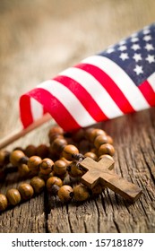 rosary beads with american flag on wooden background