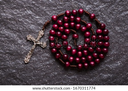 The rosary and the Christian cross lie on a dark granite stone. Photo stock © 