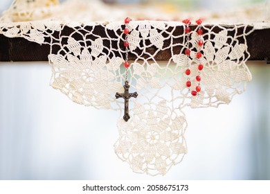 Rosary Hanging From Table On A Doily