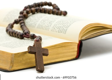 Rosary with holy bible over white background