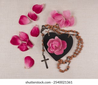 rosary  on a black heart with pink rose petals - Powered by Shutterstock