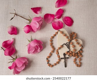 rosary on a white heart with pink rose petals - Powered by Shutterstock