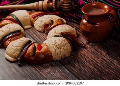 Rosca de reyes or Epiphany cake and clay mug of mexican hot chocolate on wooden table in Mexico Latin America