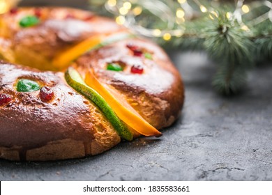 Rosca de reyes, spanish three kings cake eaten on epiphany day, on a gray rustic table