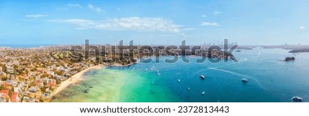 Rose bay beach on Sydney harbour in aerial cityscape panorama to distant city CBD.