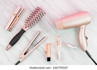 Rose Gold Hair Care And Beauty Products On Marble Countertop