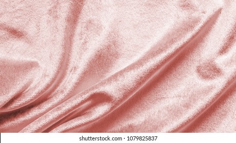 Rose gold pink velvet background or velour flannel texture made of cotton or wool with soft fluffy velvety satin fabric cloth metallic color material in wavy satin pattern