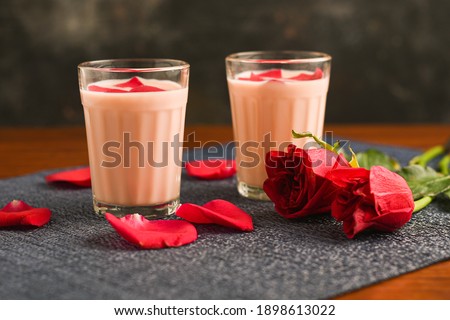 Rose milk , Rose shake , Gulab Shake with rose petals Indian valentines day drink with heart shaped red rose flowers Kerala. strawberry milk shake or Pink Tea , Gulabi Chai refreshment Kashmir India.