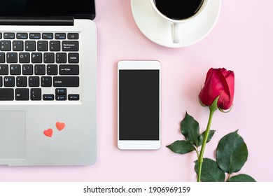 Rose, Mobile Phone, A Cup Of Coffee And Laptop On Pink Table Background. Valentines Day, Anniversary, Birthday Concept. Flat Lay, Top View And Copy Space.