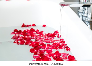 Rose petals put in bathtub for romantic bathroom in honeymoon suit.Arranged by interior designer for honeymoon couple. Scent of rose make relax. Spa shop put flowers in the tub with towels for lover. - Powered by Shutterstock