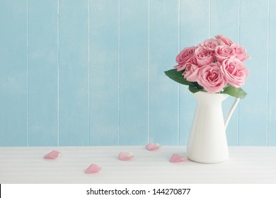 Rose placed on the desk in blue background - Powered by Shutterstock