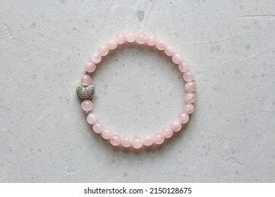 Rose quartz bracelet. Bracelet made of stones on hand from natural stone Rose quartz. Bracelet made of natural stones with an elastic band. Handmade jewelry bracelets on light modern background.