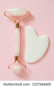 Rose Quartz Facial Roller And Gua Sha Stone On Pink Background