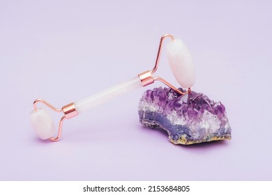 Rose Quartz Facial Roller On Amethyst Crystal Stone, Close Up.