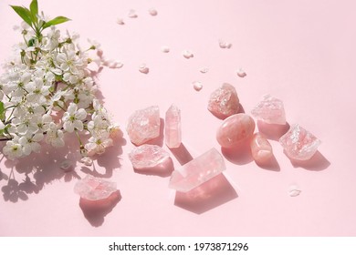 Rose quartz minerals set and white flowers on abstract pink background. gemstones for Magic Crystal Ritual, Witchcraft. esoteric spiritual practice for love, wellbeing, meditation, mental health