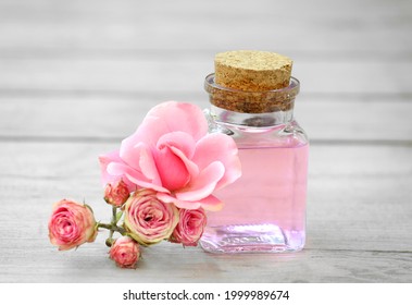 Rose Water Glass Bottle Decorated With Flowers.Essential Oil Spa Treatment. Aromatherapy. Beauty And Skin Care. Face Cosmetics. Essence For Body Massage.