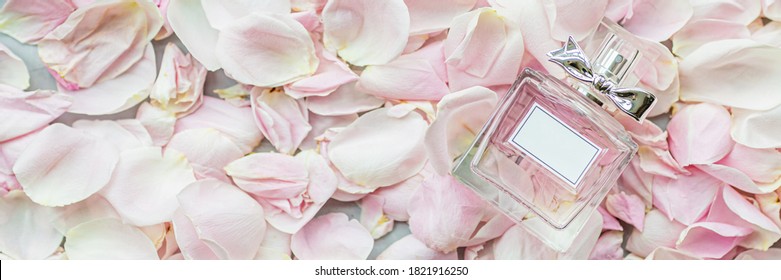 Rose Water Or Oil In Glass Bottle On Pink Fresh Rose Petals Background, Beauty, SPA Concept And Aromatherapy. Flat Lay, Top View, Mockup