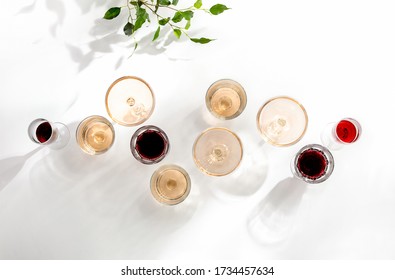 Rose wine assortment, top-down view of various wine glasses full of rose and red wine, standing on a white table surface  reflecting soft sunshine rays - Shutterstock ID 1734457634