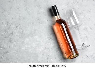 Rose Wine In Bottle And Empty Glass On Gray Grunge Background Flat Lay. Top View