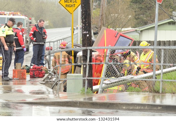 ROSEBURG, OR - MARCH 19: Emergency workers\
extricate a victim from a single car, rollover accident during a\
spring rain in Roseburg Oregon, March 19,\
2013