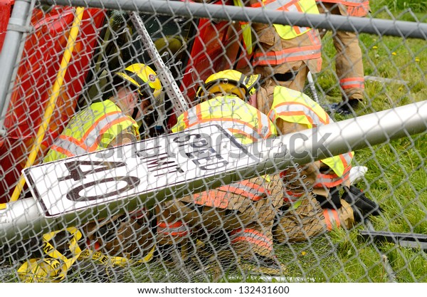 ROSEBURG, OR - MARCH 19: Emergency workers\
extricate a victim from a single car, rollover accident during a\
spring rain in Roseburg Oregon, March 19,\
2013